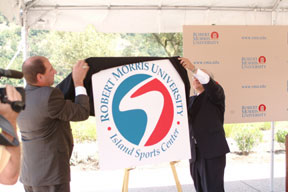 Vic Gregovits and President Nicholson unveil the new logo<br>for the Robert Morris University Island Sports Center.