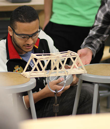 An engineering student works on an experiment to test load bearing.